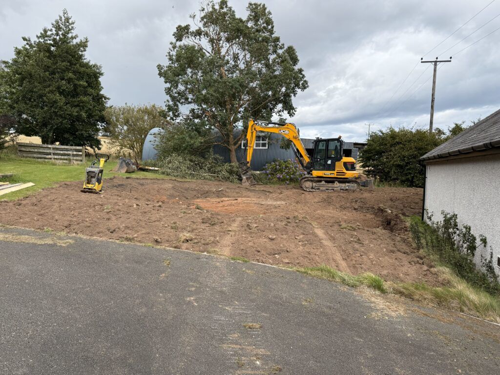 Construction site with machinery and trees.